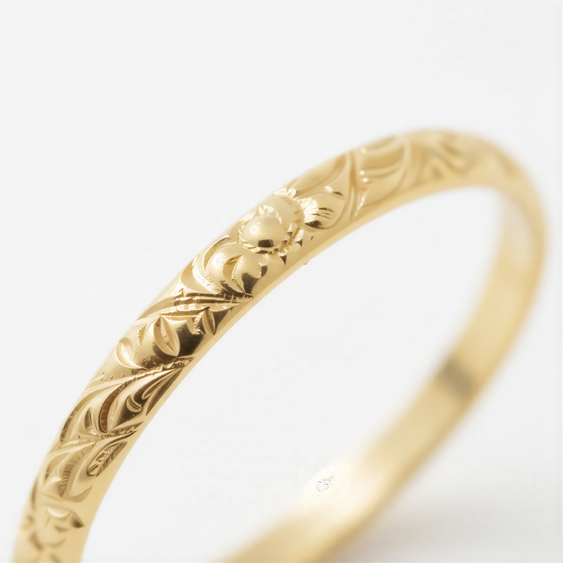 A close-up view of a gold ring with intricate floral designs.