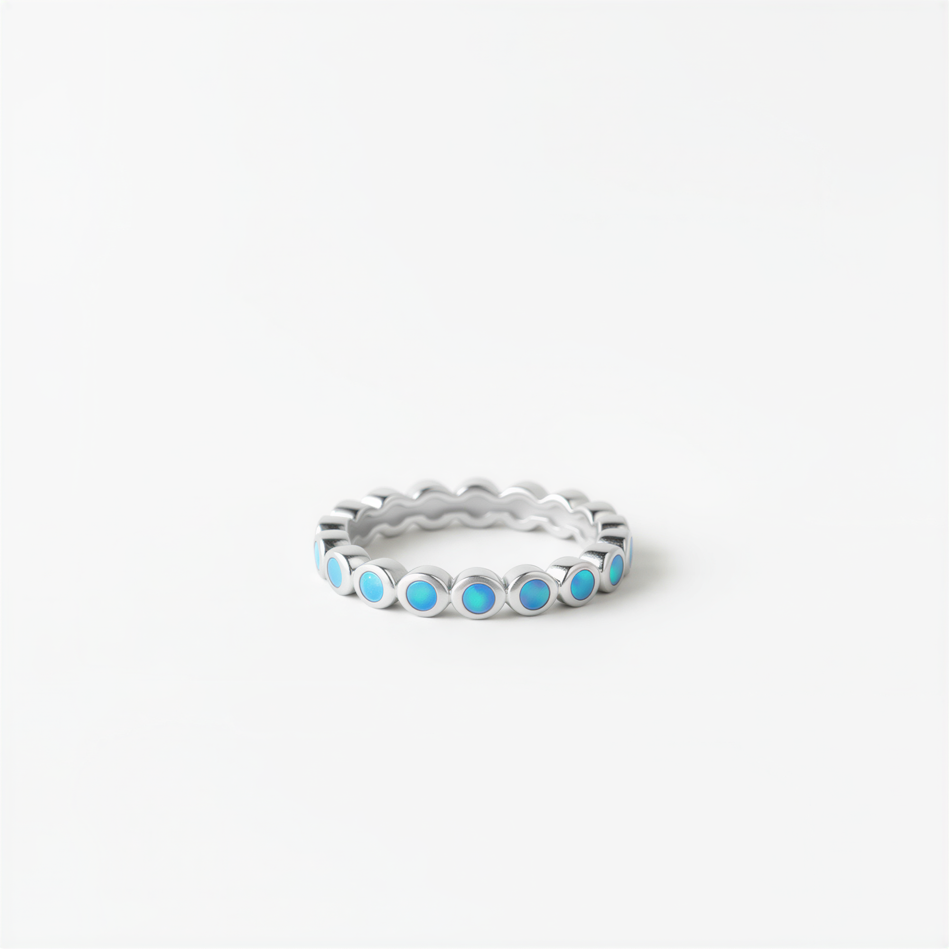 A silver ring with blue stones set in a scalloped design.